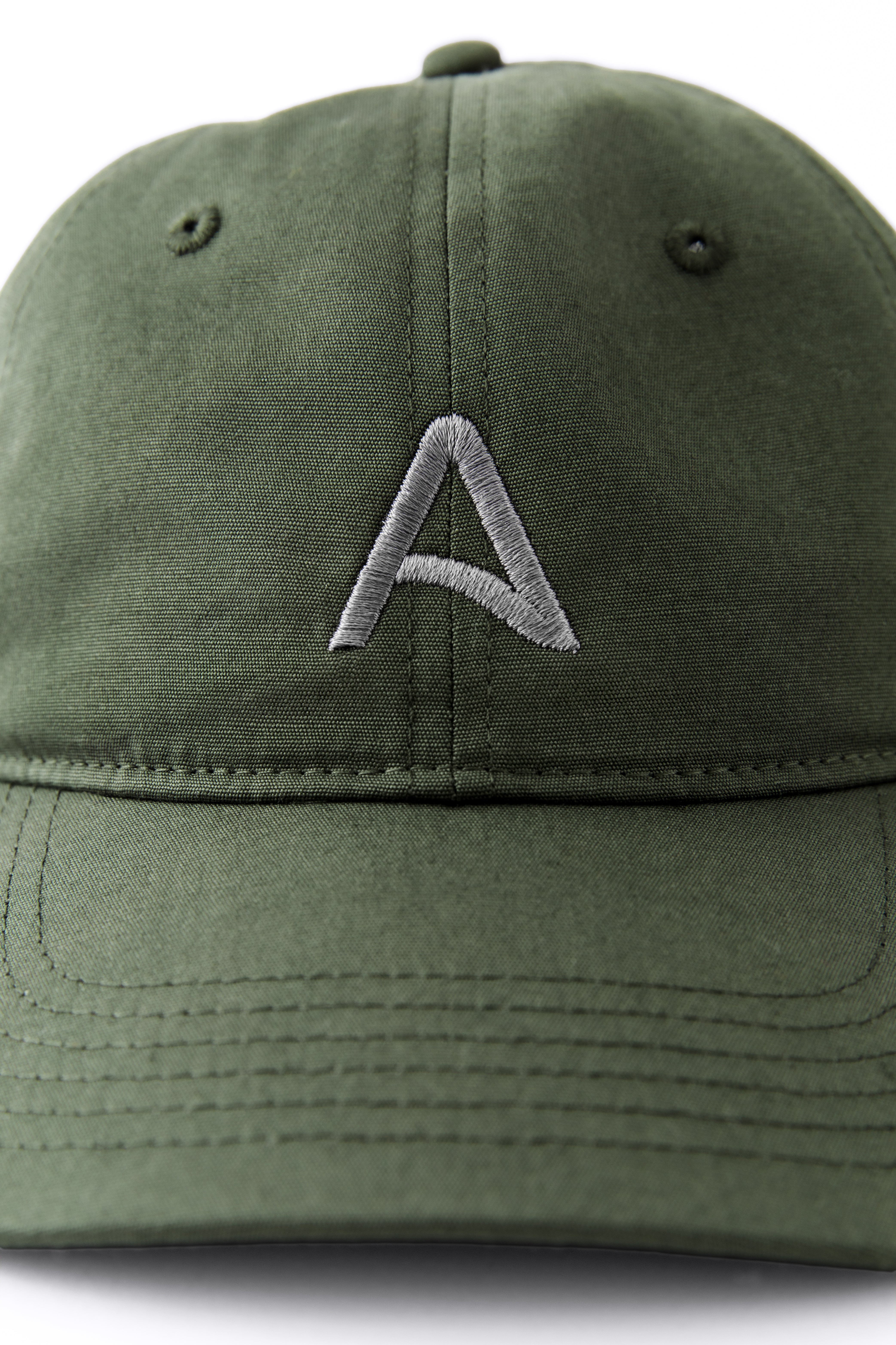 Front view of an Avelamer Caledonia Cap in Cypress Grove green with embroidered gray A-flag logo on a white background
