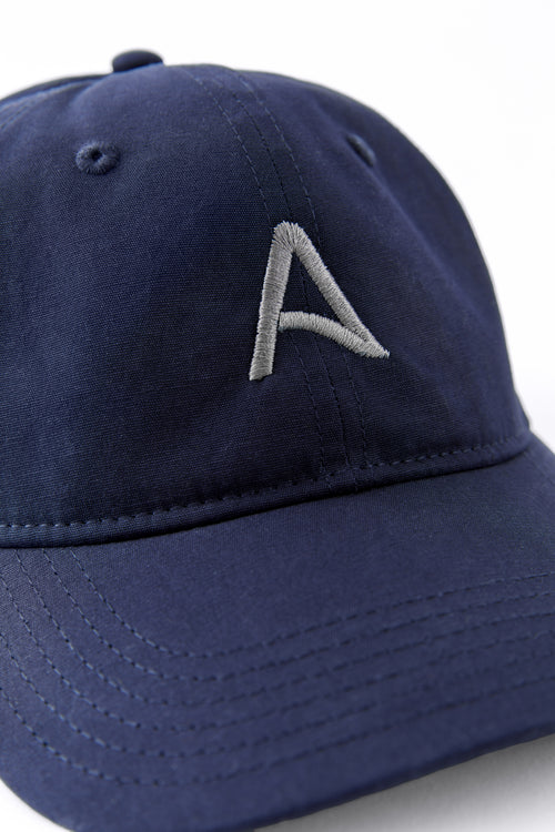 Front view of an Avelamer Caledonia Cap in Deepwater navy with embroidered gray A-flag logo on a white background