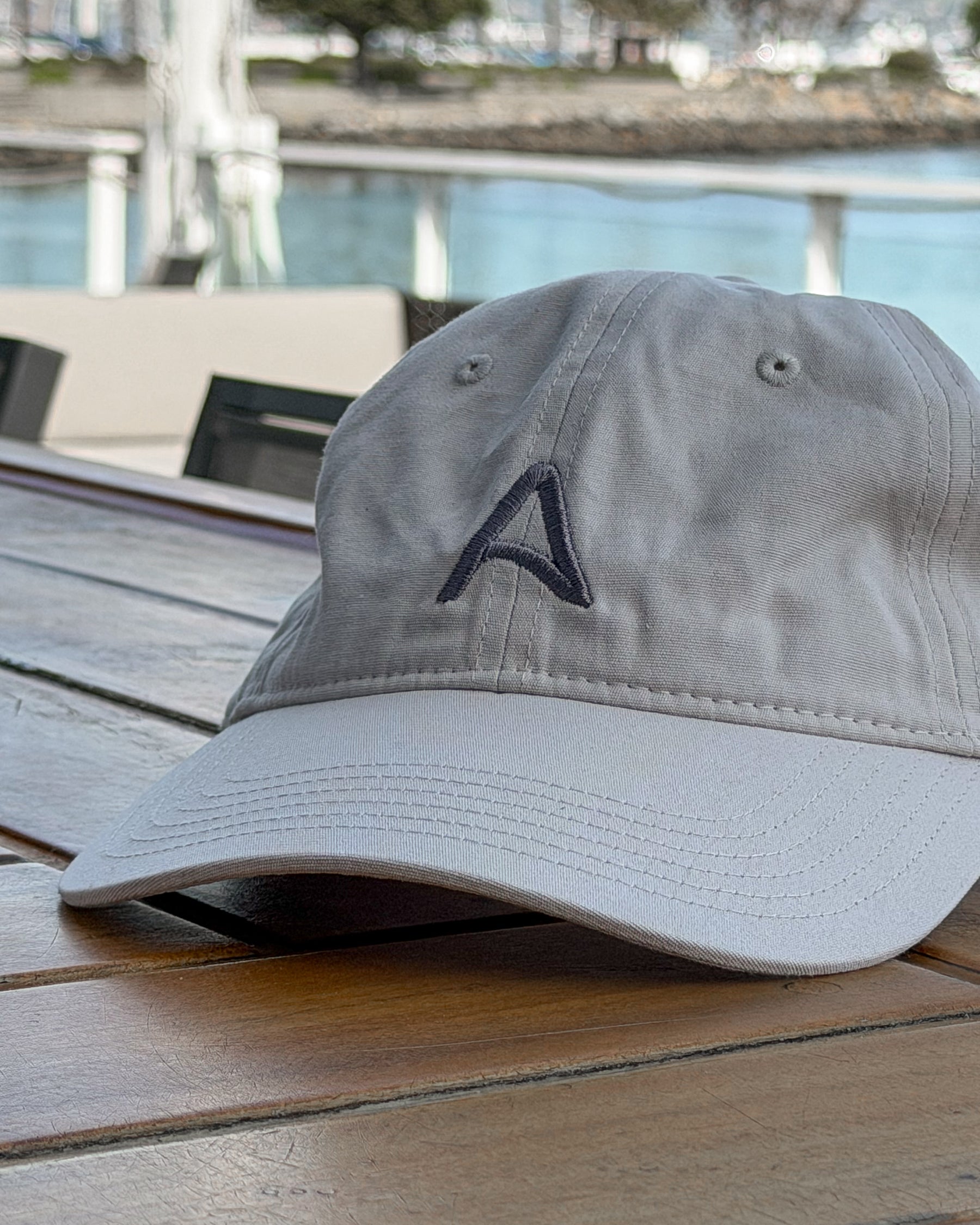 Avelamer Caledonia Cap in Mainsail off-white on a bar with a Sausalito, California marina in the background. 