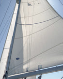 Close-up of a white mainsail against a clear blue sky