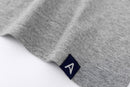 Close-up of Avelamer Ebbide Tee in Morning Fog heather gray with blue A-flag logo woven hem label