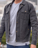 Person wearing a dark gray jacket over a gray shirt with a blurred background