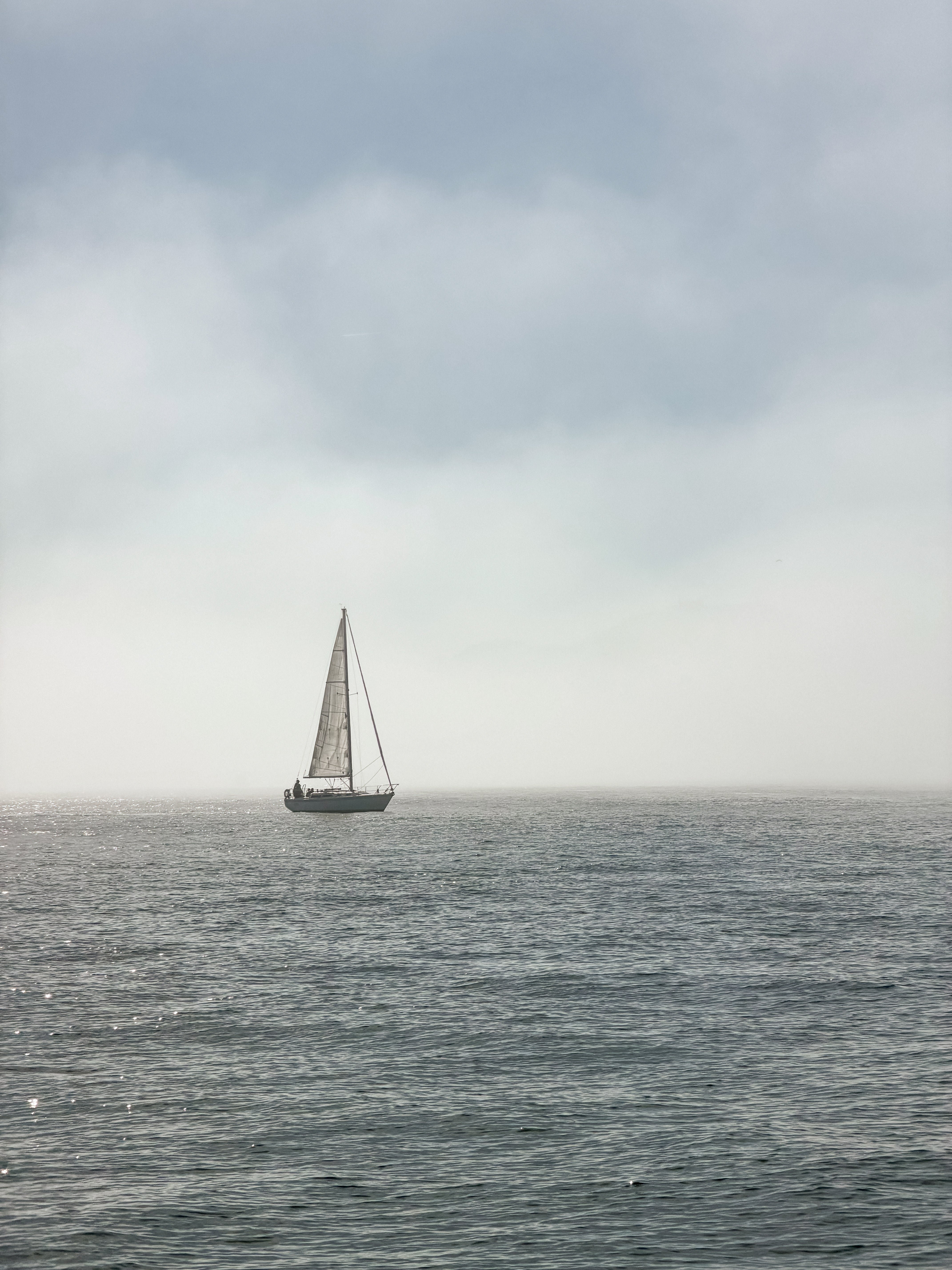 Sailboat in San Francisco Bay on a calm sea under in heavy fog conditions as part of the Avelamer brand world