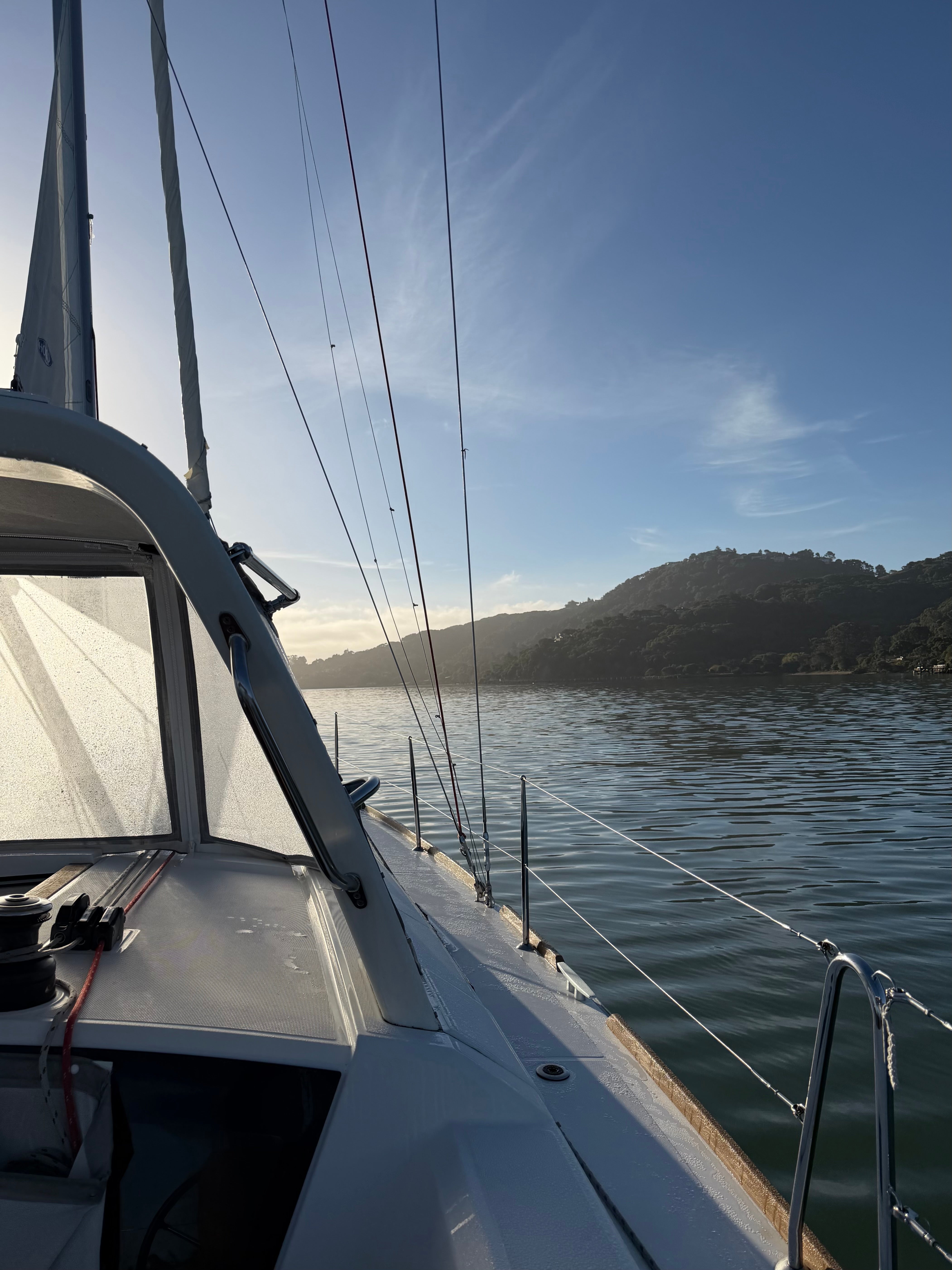 Sailboat cockpit with bright sunrise beginning to filter through the dodger