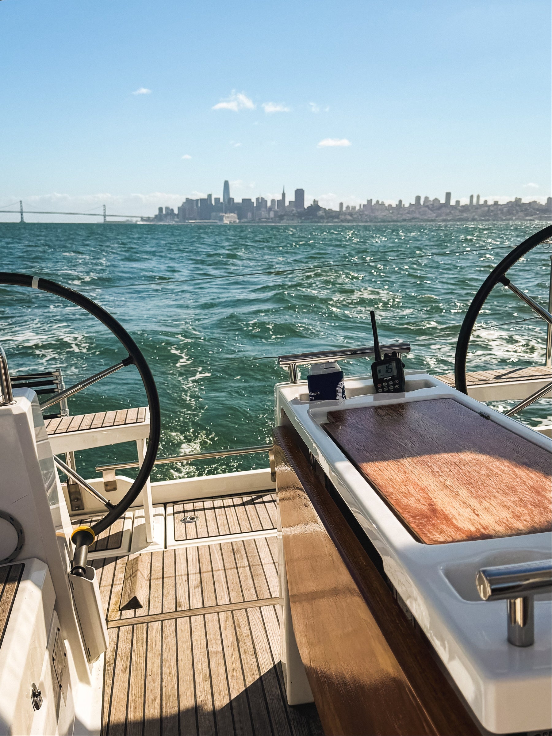 Sailboat steering wheels and center console with San Francisco Bay and the San Francisco city skyline in the background