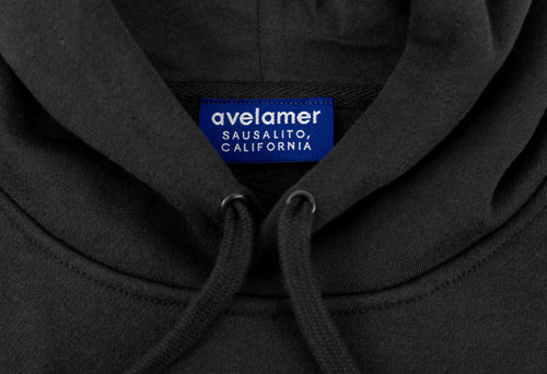 Close-up of Avelamer Sausalito Hoodie in Headland Shadow dark gray with a woven branded neck label