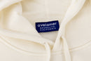 Close-up of Avelamer Sausalito Hoodie in Mainsail off-white with a blue woven branded neck label