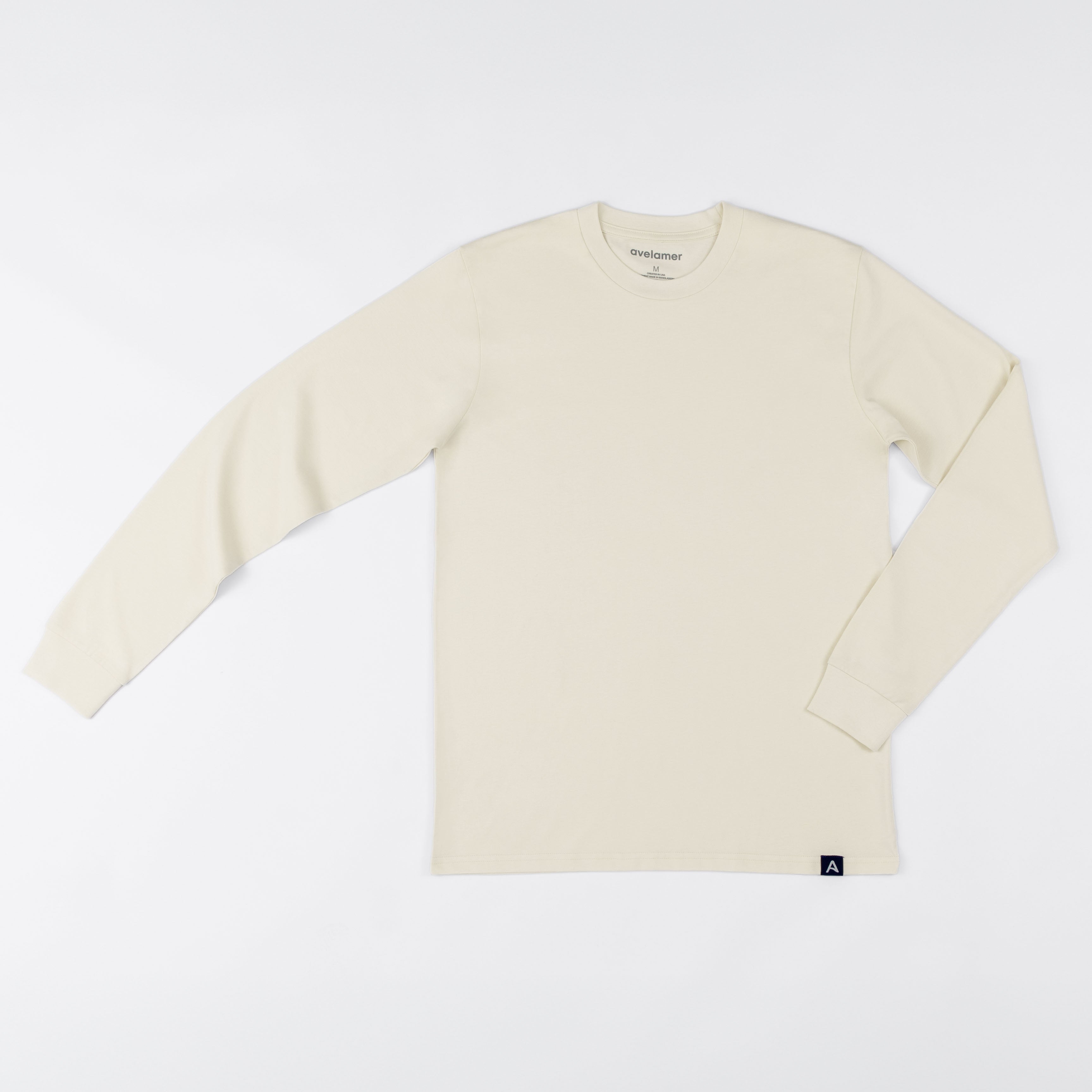 Avelamer Spencer Long Sleeve tee in Mainsail off-white with a blue Avelamer A-flag woven hem label. 